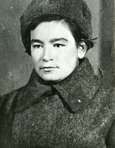 Nina as a young adult wearing her soldier's dark wool coat uniform and hat