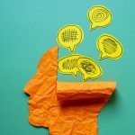 Photo of a head made of crumpled paper with yellow thought bubbles that symbolize confusion and stress.